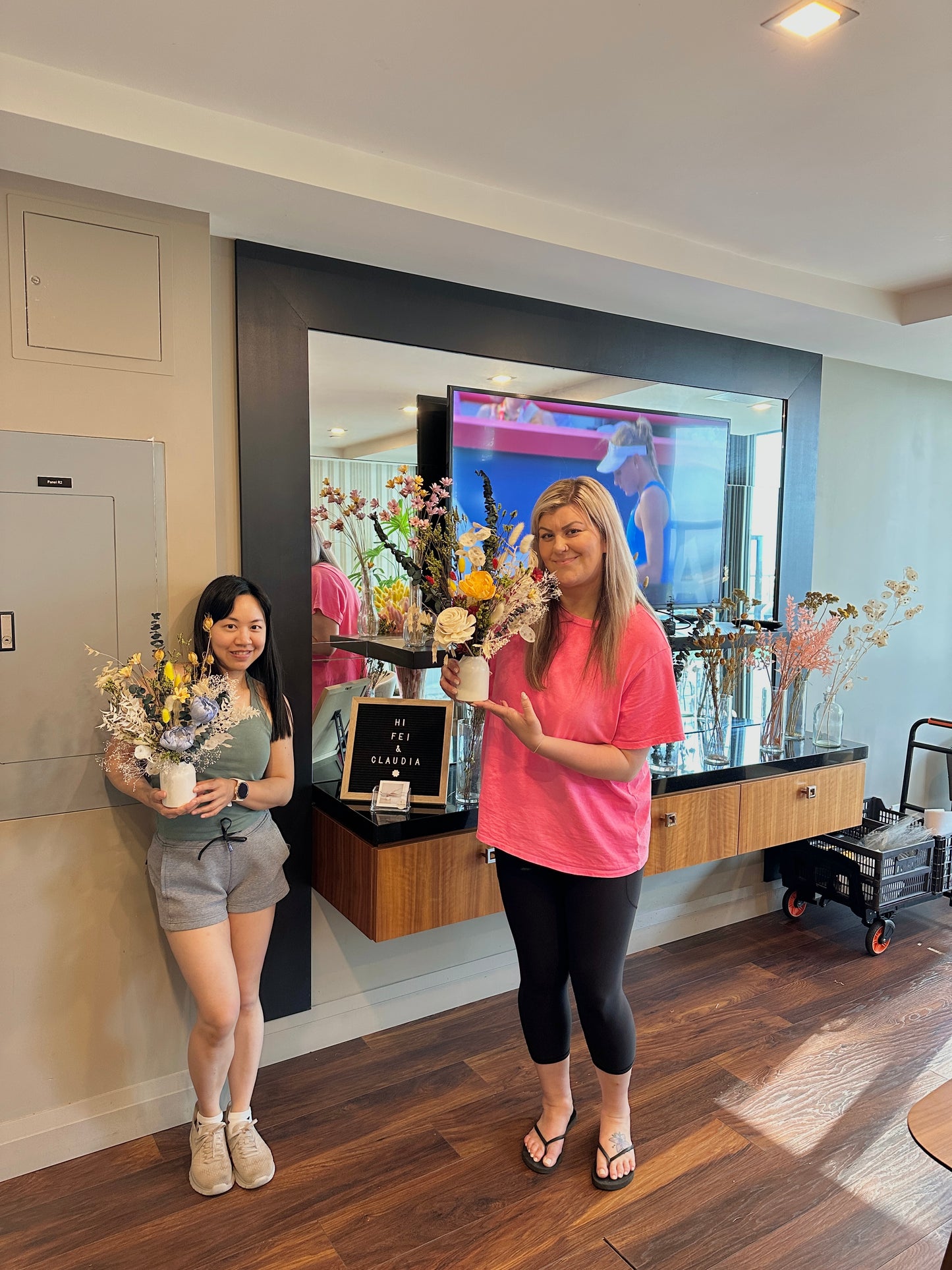 Two women holding flower arrangements