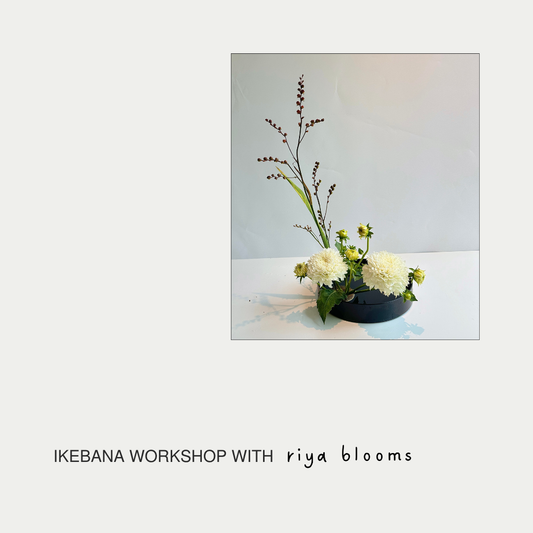 Floral arrangement in a black low bowl on a white surface with 'Ikebana Workshop with riya blooms' text.