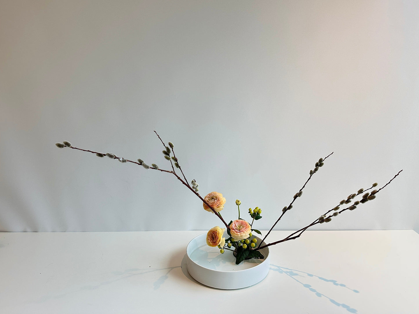 Small floral arrangement on a white surface with a plain background