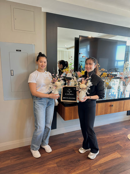 Two people holding bouquets of flowers in a modern room