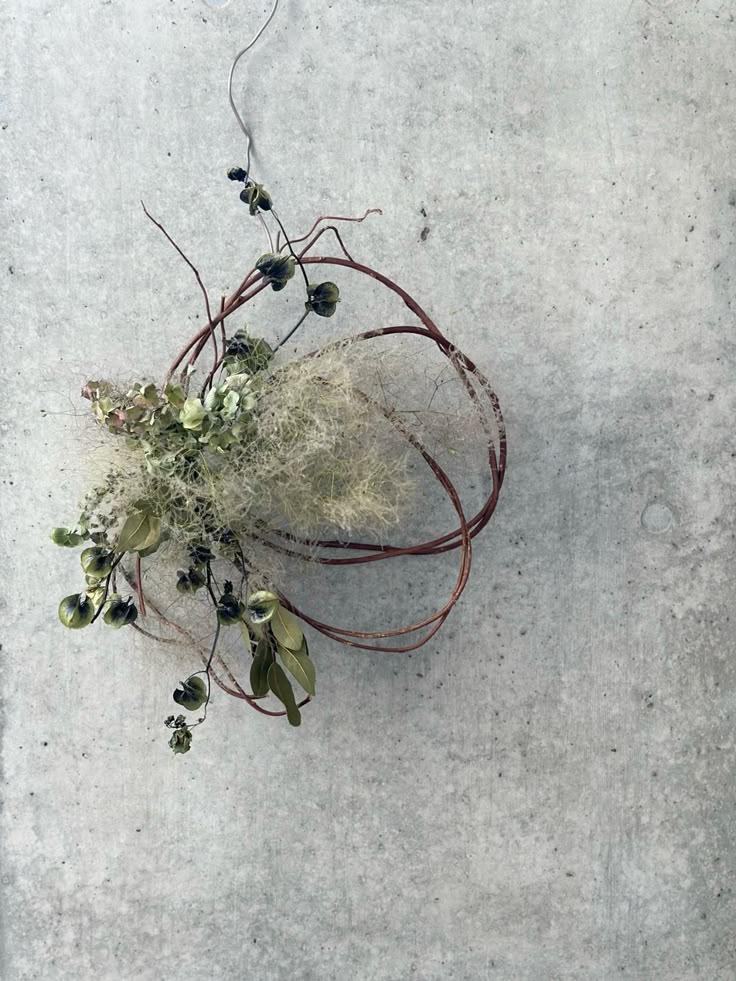 Decorative wreath with greenery and twigs on a concrete surface
