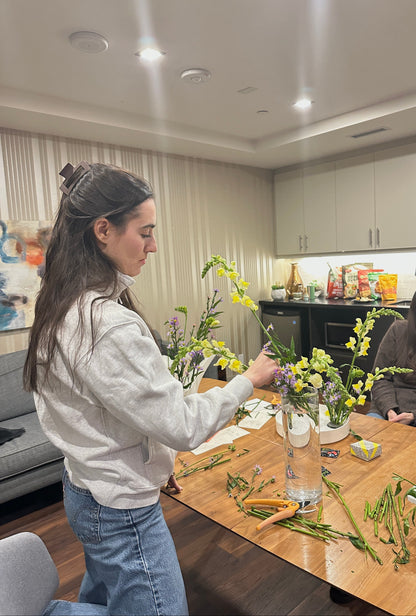 Two women arranging flowers in a modern lounge setting