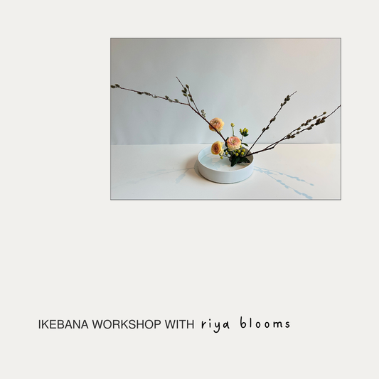 A minimalist promotional graphic with a central photograph of an Ikebana floral arrangement in a small white dish, plus the text 'IKEBANA WORKSHOP WITH riya blooms' below on a warm off-white background.